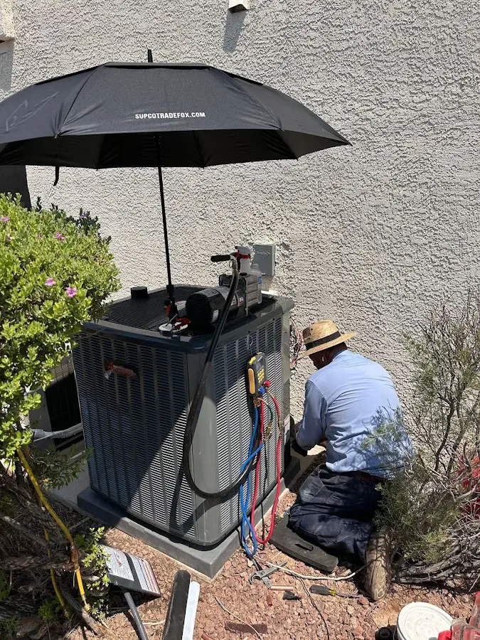 HVAC technician performing outdoor AC maintenance in Houlton